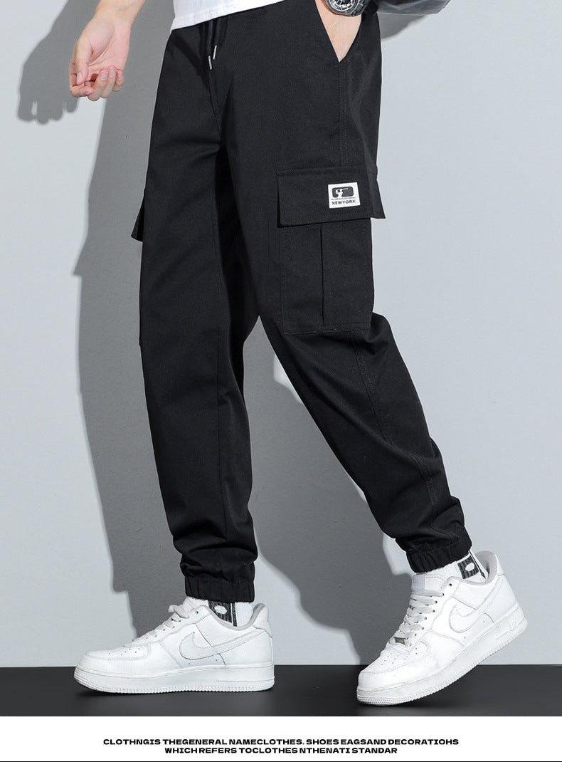 Person wearing black cargo pants with a white background