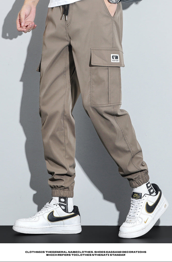 Person wearing beige cargo pants with a gray background