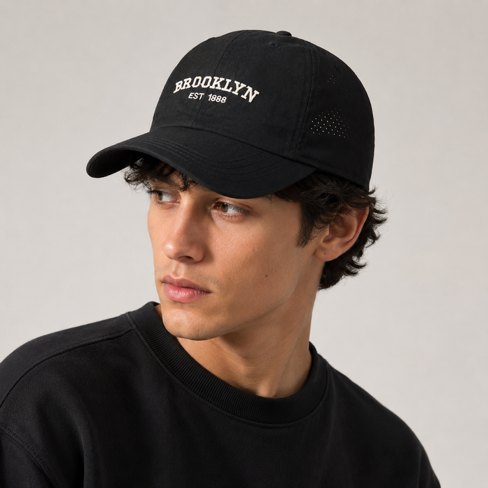 Male model wearing the black Brooklyn embroidered mesh cap in a professional studio portrait