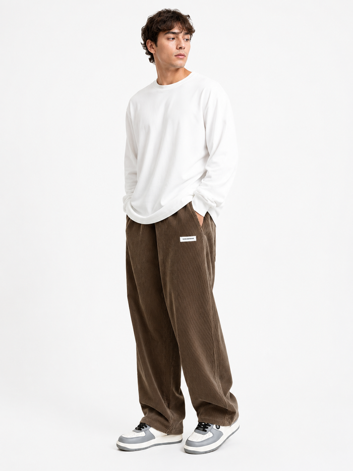 Male model wearing Calder drawstring corduroy pants in brown on a white studio background