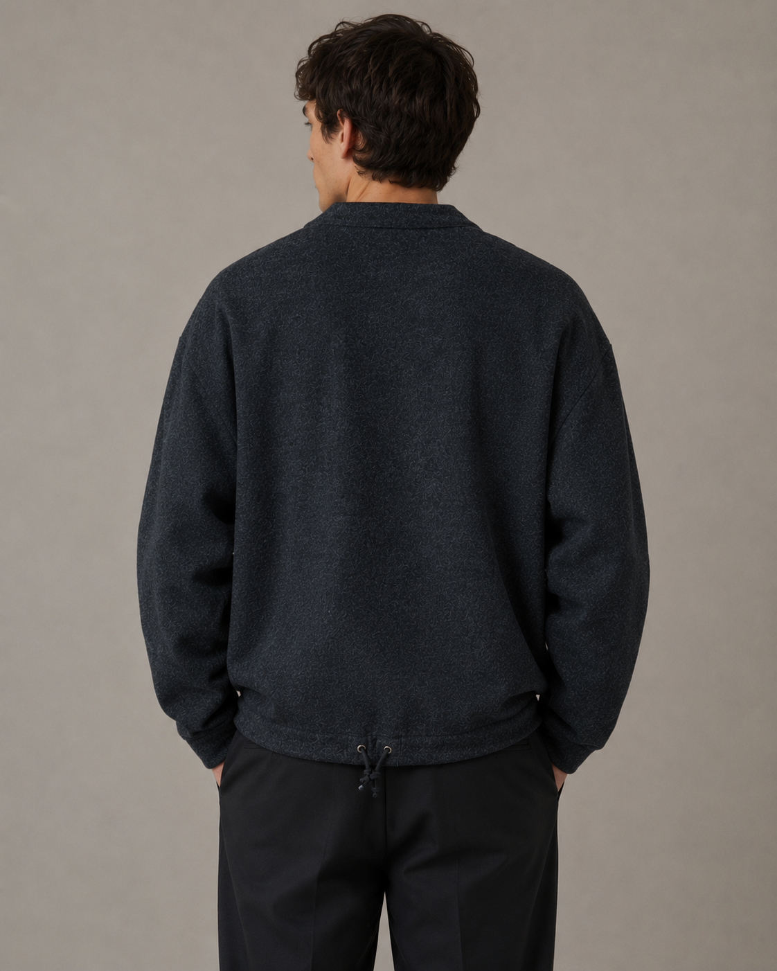 Male model wearing a dark charcoal casual cardigan jacket, back view in a professional studio
