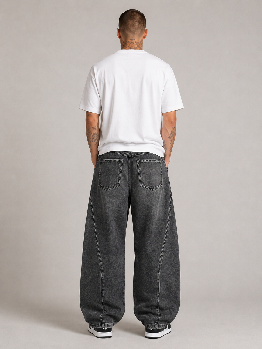 Nikolai Volkov wearing charcoal loose straight-leg utility jeans, back view in a professional studio