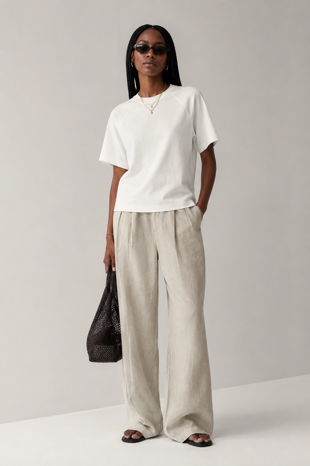 Professional female model wearing the Stitchwork Cotton Tee in beige white — front view